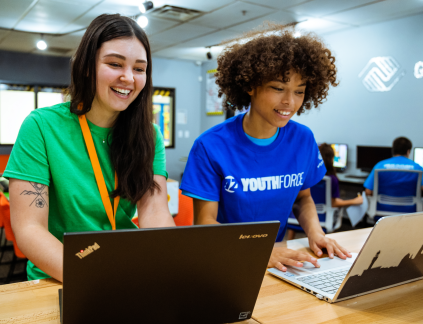 Two teens look at laptop