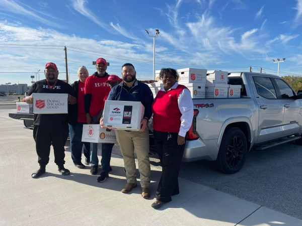 People standing with boxes of donated items in front of a Toyota Tundra vehicle as part of Day of Service.